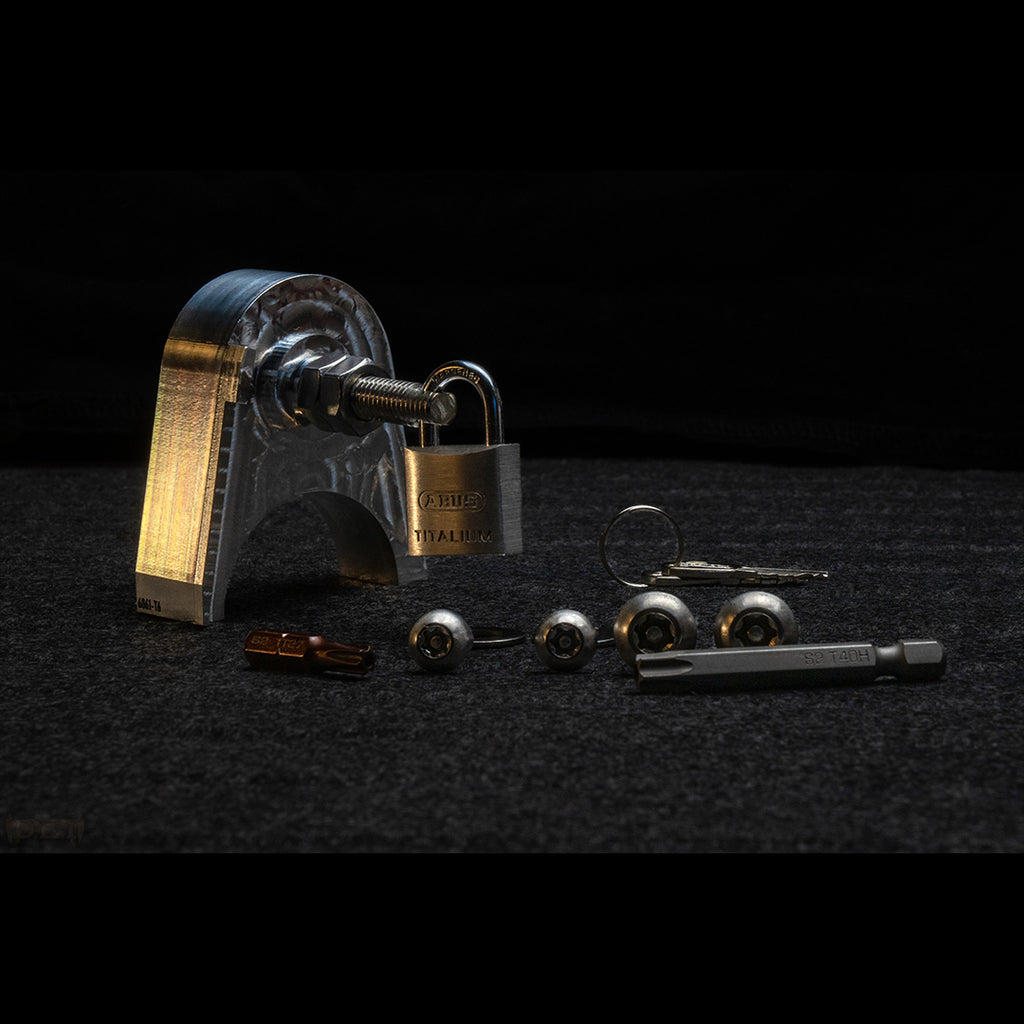 Tacoma tailgate anti-theft system layout. Billet aluminum lock block, security Torx bits, ABUS lock, and stainless hardware.